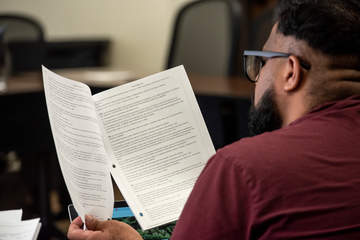 a man flipping through informational papers