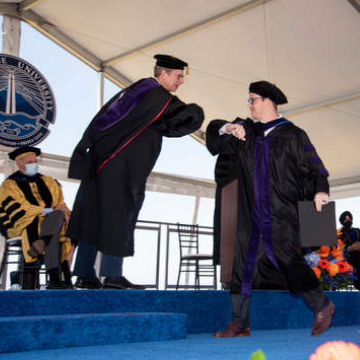 A judge shakes the hand of a Caruso Law student